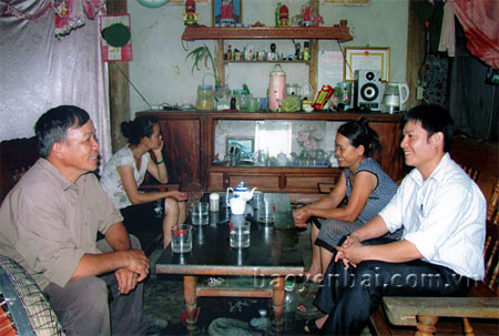 Ông Hạ (bên trái) thường xuyên đến các hộ dân tuyên truyền, vận động thực hiện nếp sống văn hóa.
